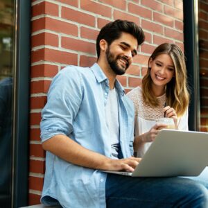Happy young couple working studying on laptop and digital devices. Business education people concept