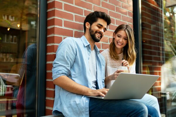 Happy young couple working studying on laptop and digital devices. Business education people concept Happy young couple working studying on laptop and digital devices. Business education people concept